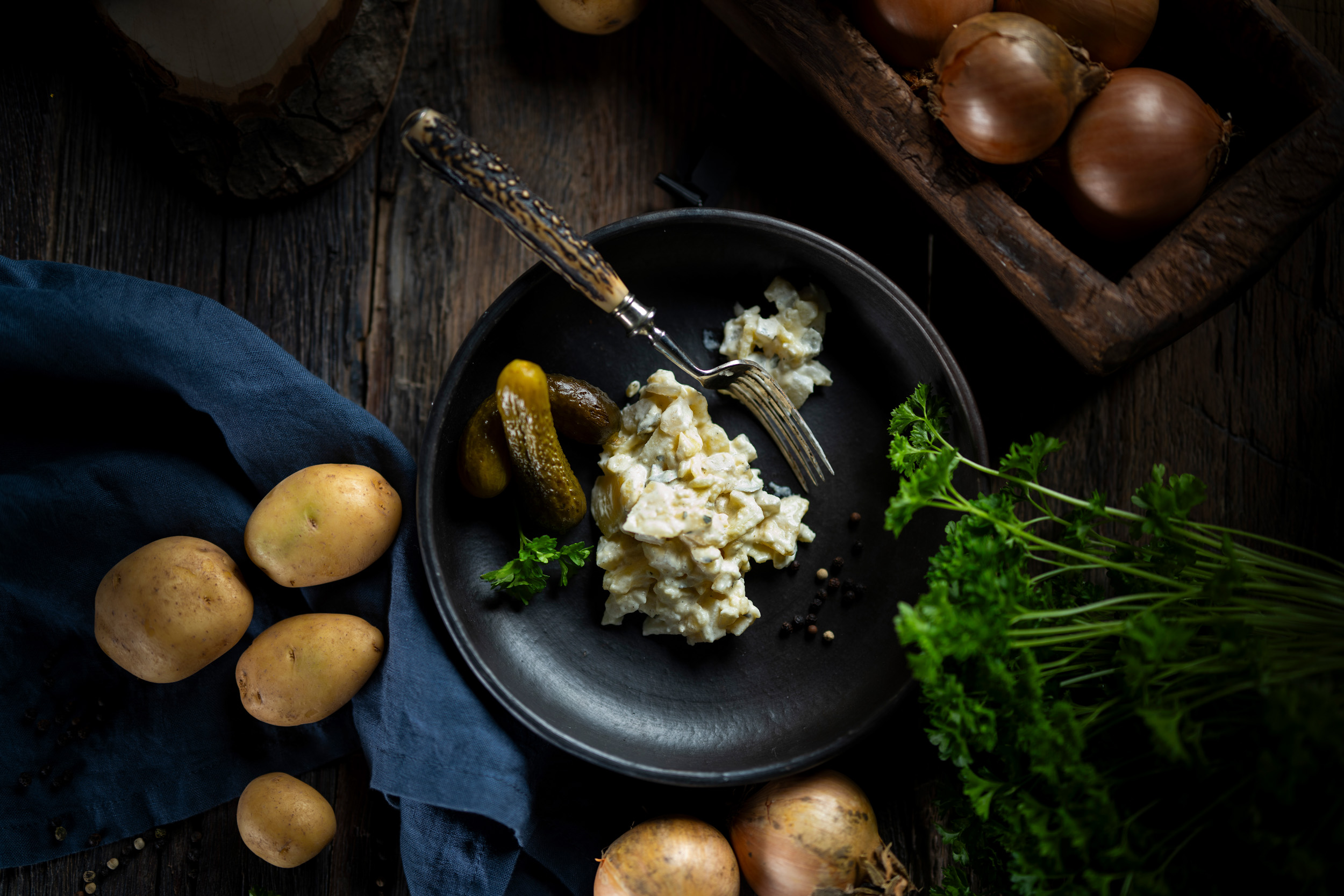 Hausgemachter Kartoffelsalat in cremiger Salat-Mayonnaise, garniert mit frischen Gurkenstücken.