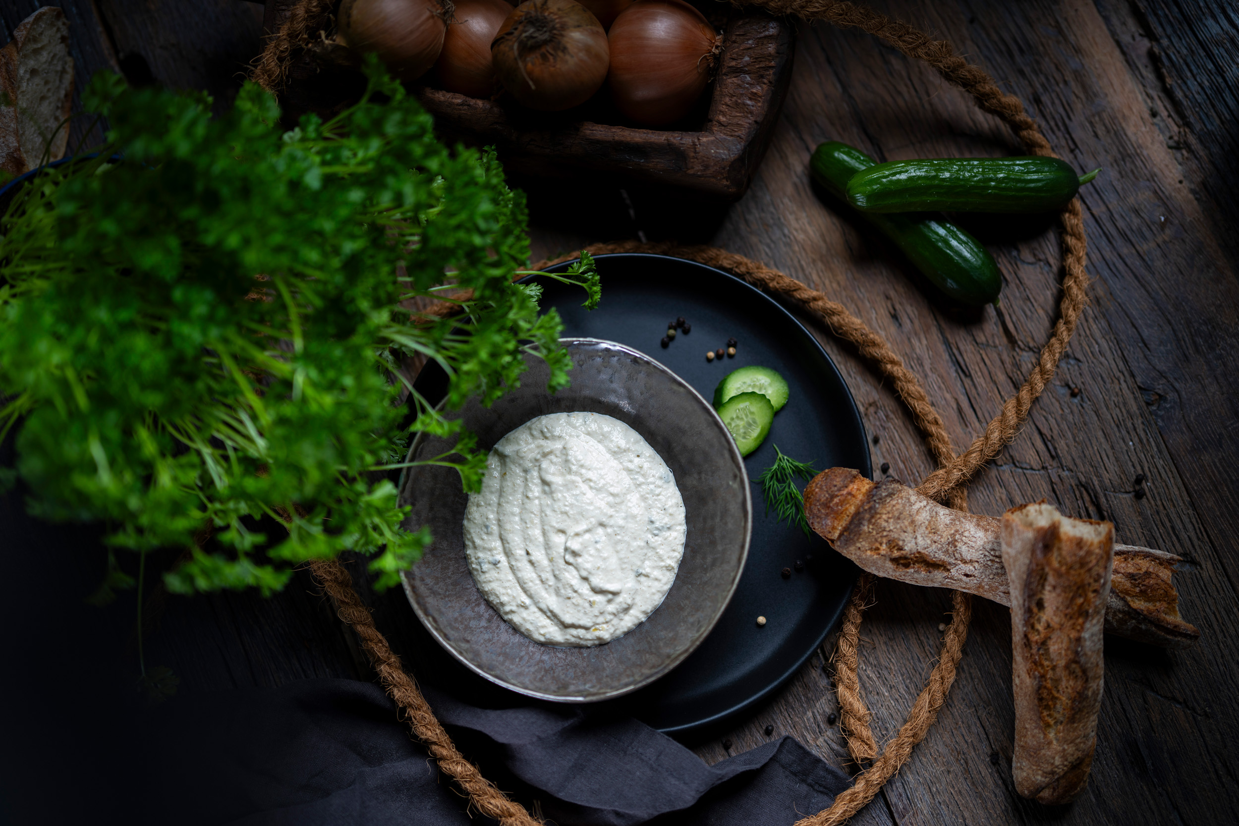 Cremige Remoulade in dunkler Schale, rustikal präsentiert mit Brot und Kräuter-Akzenten.