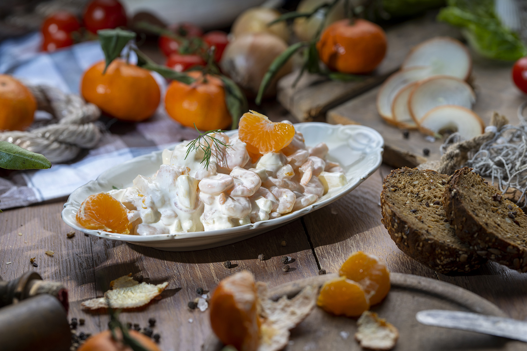 Garnelensalat Hawaii Garnelen in Mayonnaise auf Teller, garniert mit Mandarinenstücken und frischem Dill.