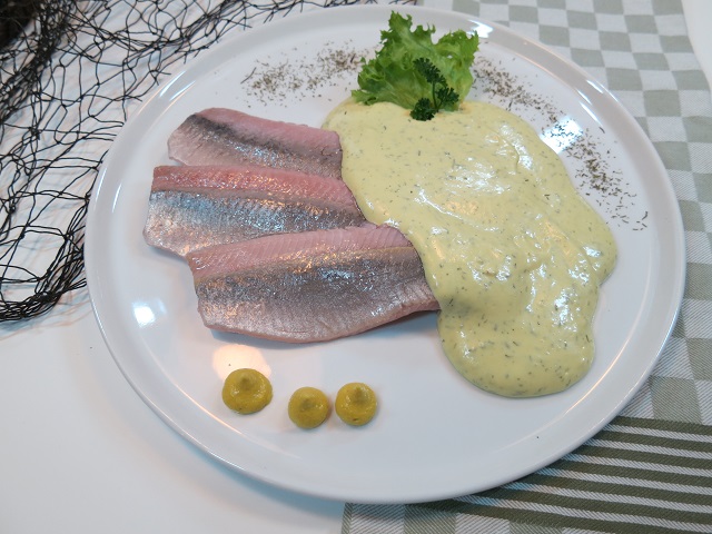 Matjesfilets in cremiger Dijon-Creme mit Kräutern – frisch, würzig und appetitlich arrangiert.