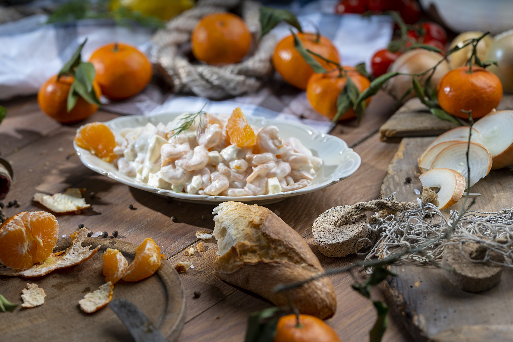 Garnelen in Mayonnaise auf Teller, garniert mit Mandarinenstücken und frischem Dill.