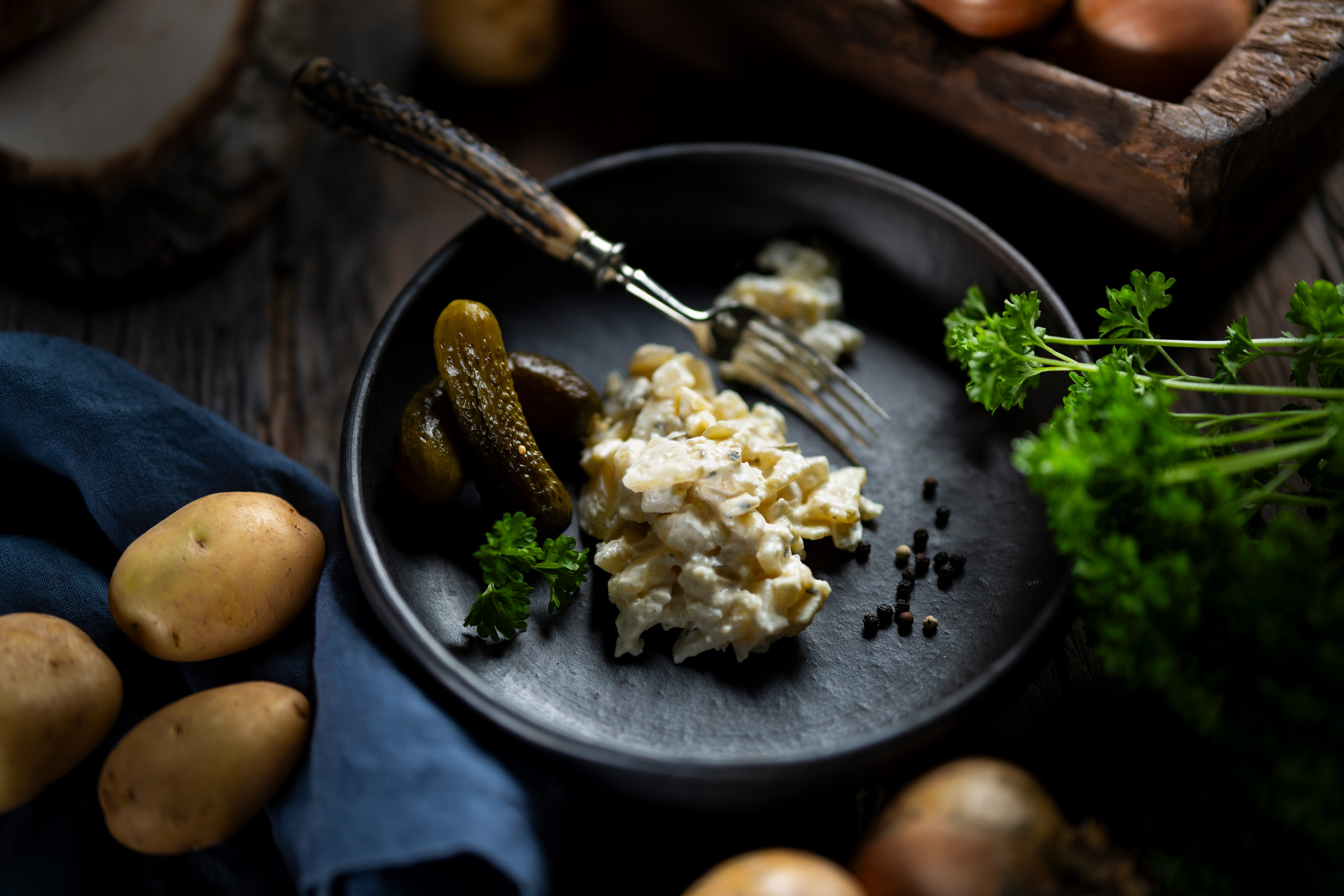 Hausgemachter Kartoffelsalat in cremiger Salat-Mayonnaise, garniert mit frischen Gurkenstücken.