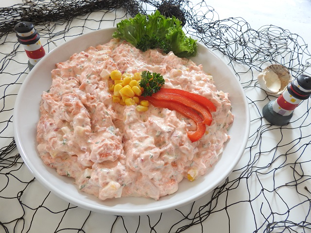 Cremiger Seelachs-Aufstrich mit Mais, Paprika und Petersilie in weißer Schüssel dekorativ angerichtet.