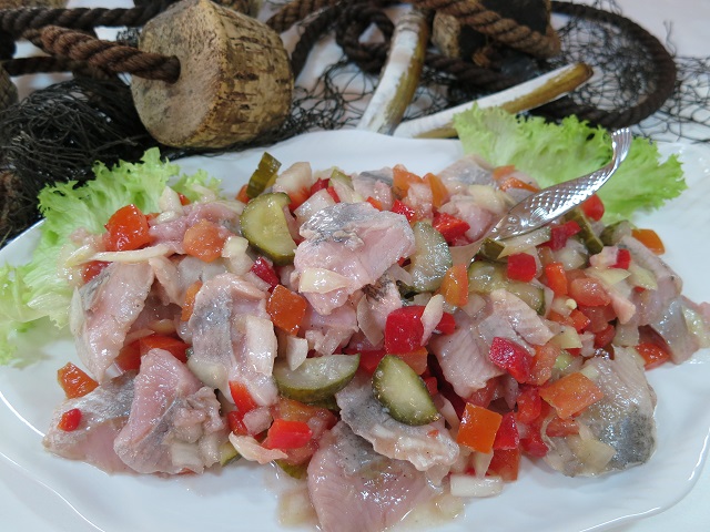 Matjessalat Natur mit knackiger Paprika Matjessalat Natur mit Paprika & Gurkenstücken auf weißem Teller mit frischen Salatblättern.