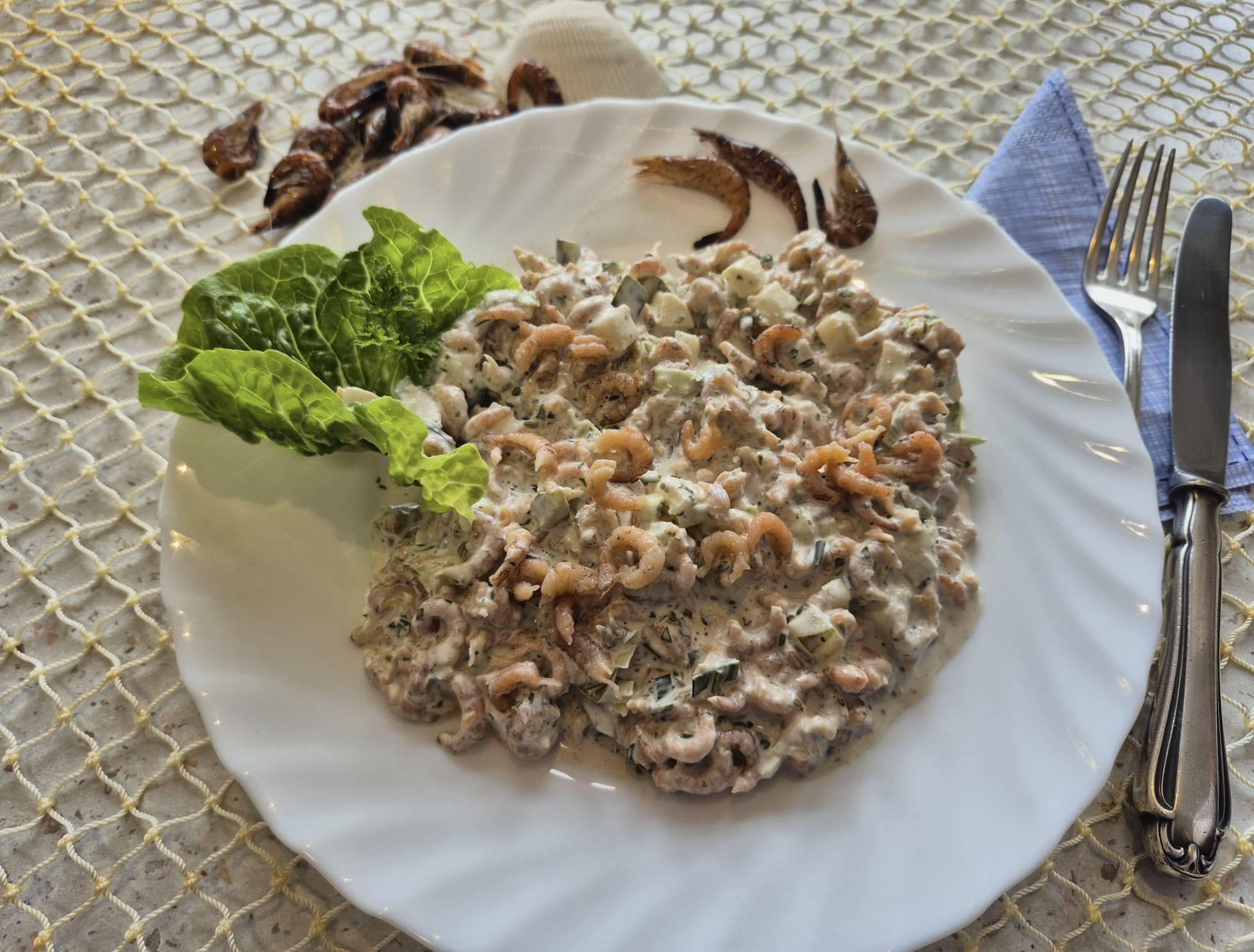 Greetsieler Krabbensalat  Krabbensalat mit Apfel, Dill und Joghurtdressing, garniert mit Salatblatt und Krabben auf Teller.