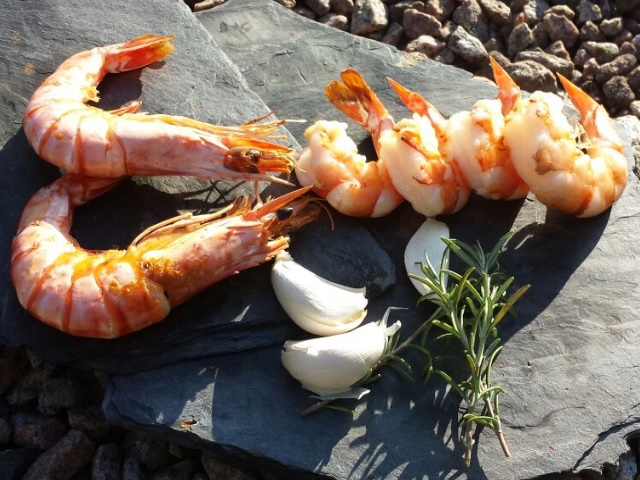 Garnelen mit Kopf fertig gegrillt auf einer Schieferplatte